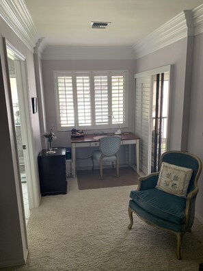 Desk and file cabinet at window with lake view. Lanai to right via sliding doors