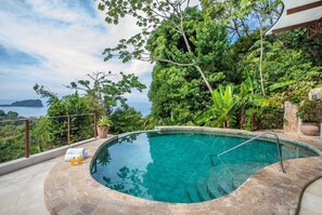 Set on a hill in the rainforest , the villa has many tremendous ocean views