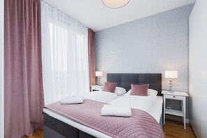 Cozy, pink bedroom with curtains.