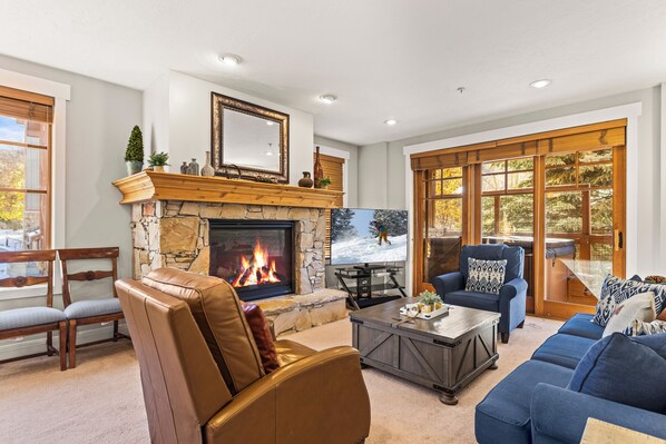 Town Pointe C101 has a spacious living room with a cozy gas fireplace and furnishings.