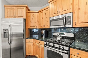 Town Pointe C101 has a well-equipped kitchen with stainless steel appliances and wood cabinetry.