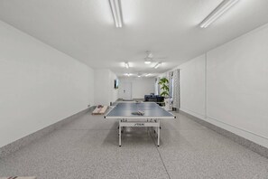 Communal rec room features a ping pong table and cornhole!