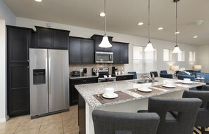 Our sleek dark cabinetry and beautiful island with a sink 