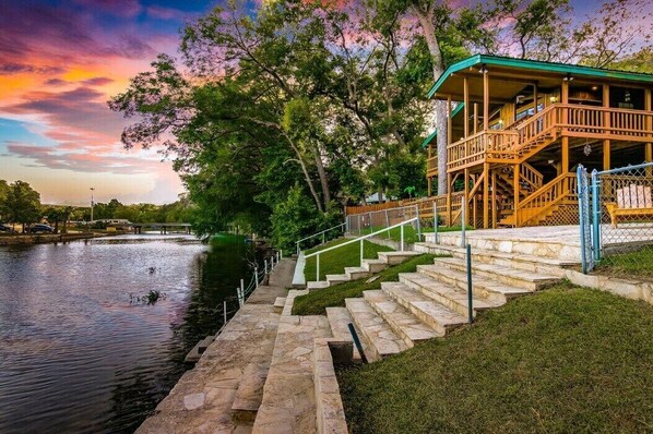 Surrounded by Trees Step outside to the riverside vacation with our home's direct river access. The exterior shot captures the tranquil ambiance, promising a peaceful and unforgettable stay