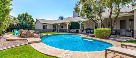 Backyard with covered patio, multiple seating areas, ping pong table, yard games, BBQ grill, fire pit, sun loungers, and sparkling pool.