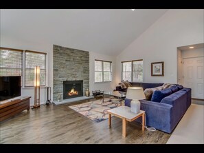 living room with bluestone fireplace and log fire
