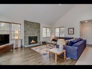 living room with bluestone fireplace and log fire