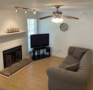 Living area with television and sofa. Fireplace is NOT operational