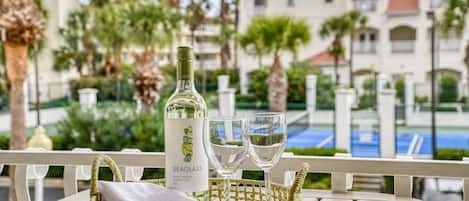 The balcony off the living area is a breezy overlook of the tennis courts with glimpses of the ocean and waving palms.