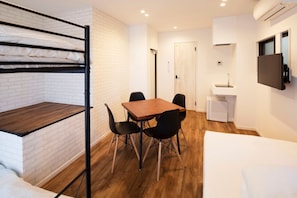 The refrigerator and mini kitchen can be seen at the back right