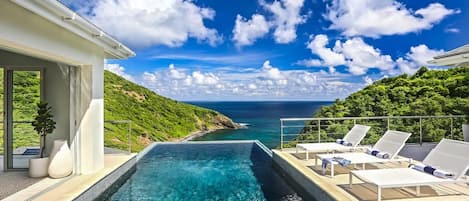 Infinity edge pool overlooking the Caribbean Sea and lush green hillsides