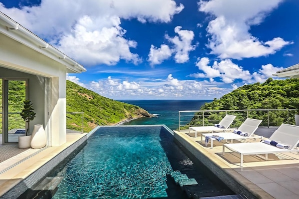 Infinity edge pool overlooking the Caribbean Sea and lush green hillsides