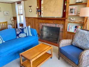 Sea Breeze suite living room with decorative fireplace and sea view.