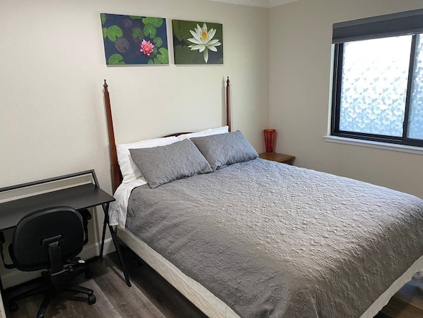 Private bedroom with queen sized bed, closet, and a desk