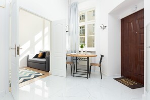 A dining space with a large window, white walls, and minimalist furniture, combining simplicity and elegance.
