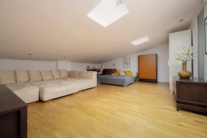 A cozy attic-style bedroom featuring a wide bed, soft lighting, and ample storage space.