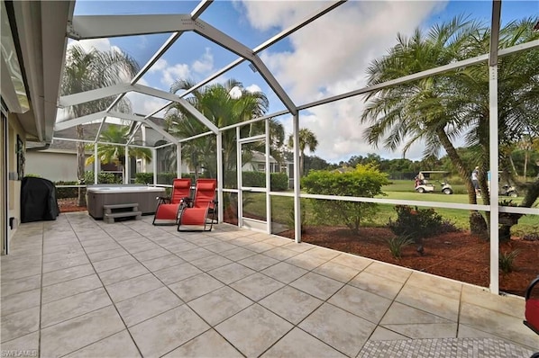 CC21040 - The screened in patio offers a covered dining area, seating and lounging area and a hot tub.