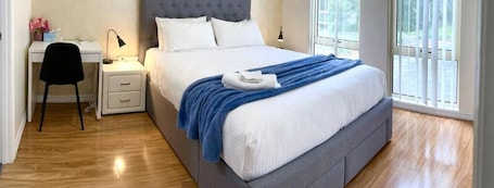 Master bedroom with updated air-conditioner, luxury upholstered bed and work desk. Bed and bath linen hire included. Design & colours of linen will vary.