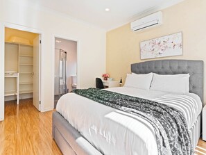 Master bedroom with updated air-conditioner, luxury upholstered bed and work desk. Bed and bath linen hire included. Design & colours of linen will vary. 