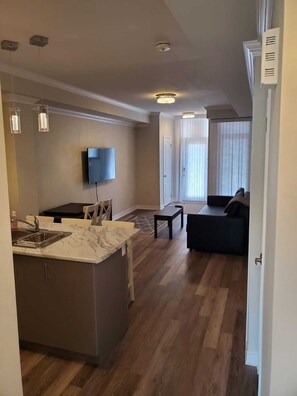 View of kitchen and living area from back entrance and bedroom entrance. 