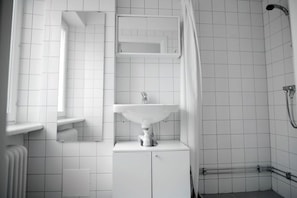 The bathroom is spacious with a shower and sink. The WC is separated from the shower bathroom.