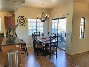 The dining table seats 6 guests with additional seating for 2 at the kitchen counter