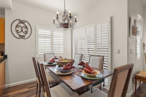 The dining table seats 6 guests with additional seating for 2 at the kitchen counter