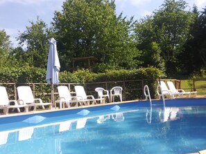 Swimming pool in gardens, heated with deck and sun loungers.
