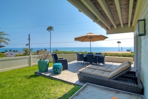 Patio area with 2 sets of lounge chairs, dinning table and BBQ.  