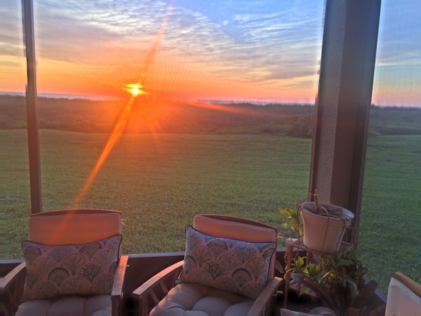 View of the sunrise over the ocean from our screened patio