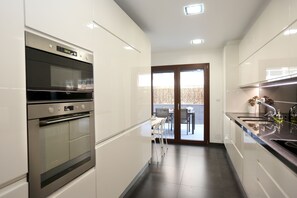 Cozinha moderna, totalmente equipada, também com acesso ao terraço.