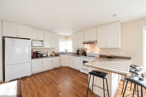 Fully Stocked Kitchen includes dinnerware, silverware, pots and pans, Keurig, drip coffee maker, spices and herbs, dual toaster, paper towel, dish soap, etc. Seating for 4 extra at the bar top.
