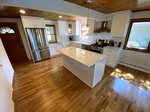 Brand new kitchen with quartz countertops and new appliances.