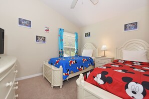 Kid-friendly bedroom with cheerful Disney-themed decor and cozy beds.