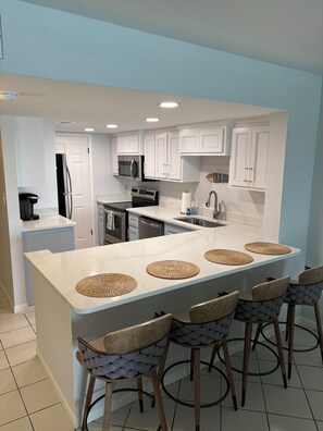 Fully equipped and open kitchen. Enjoy views all the way out to the Gulf!