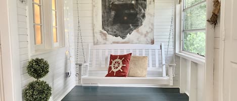 air conditioned front porch with swing and breakfast table