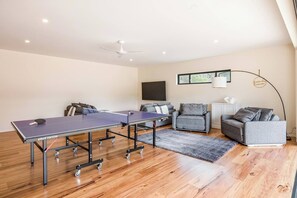 The ultimate hangout zone, complete with plush seating, a massive smart TV and a ping pong table for hours of entertainment.