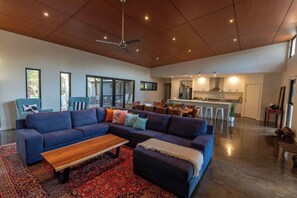 Stretch out and unwind on the oversized lounge in the sunlit main living area—perfect for fireside chats and relaxed evenings.
