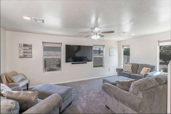 Gather in the Living Area to Watch your Favorite Show on this Large Smart TV