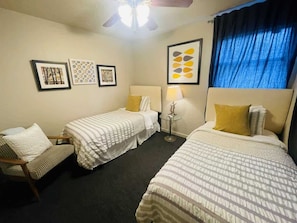 Perfect for sharing with friends or family, this cozy bedroom features twin beds and a comfortable seating area.
