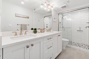 The ensuite primary bathroom boasts a large vanity and walk-in shower