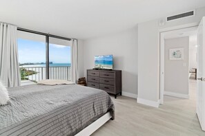 In the primary bedroom, simply open your eyes to check the weather and beach conditions.