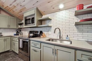 A kitchen with Stainless Appliances, Dishes, and Cookware to make home cooked meals.