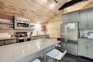 Kitchen area (complete with a sink, countertop, fridge, microwave, stove, utensils, coffee maker)