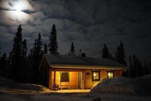 Außenansicht des Gebäudes. Blockhütte bei Vollmond im Winter