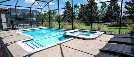 Private pool area with removable mesh fence, jacuzzi spa, and loungers.