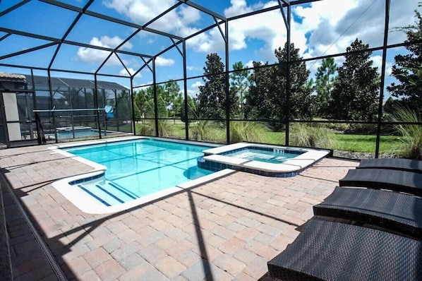 Private pool area with removable mesh fence, jacuzzi spa, and loungers.