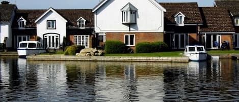 The Peninsula Cottages from across the River Bure. (Albion and Wherry centre).