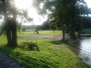 Seeufer mit Gras- und Sandstrand