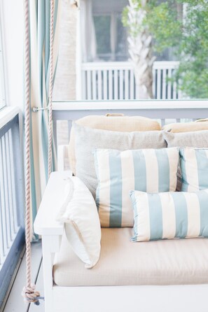 Cheery canopy striped pillows and curtains on the front porch